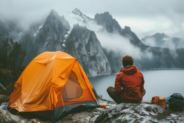 Amidst the tranquil winter landscape, a lone adventurer takes shelter in their tent, surrounded by the rugged mountains and vast sky above - obrazy, fototapety, plakaty