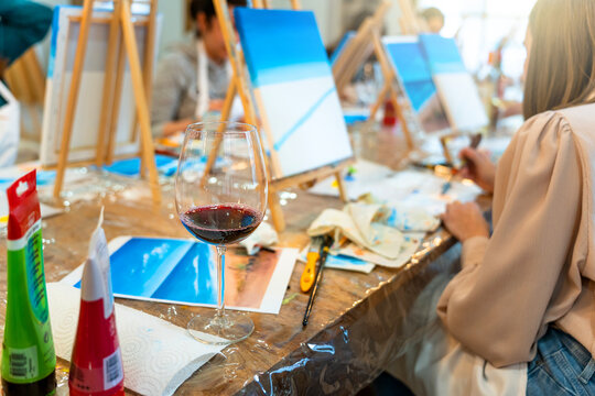 Sip and Paint Event. Painting with a glass of wine in hand