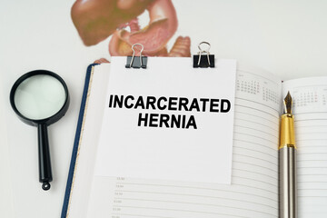 On the table there is a magnifying glass and a notepad with the inscription - Incarcerated hernia