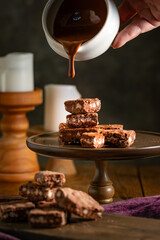 Pouring melted chocolate over brownies.
Bakery, confectionery concept.