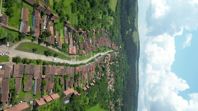 Aerial view of traditional Village Viscri. Situated in Romania, Brasov this village become a famous travel destination after King Charles the III bought a vacation home here. Drone backward. Vertical 