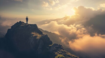 An individual stands atop a rugged mountain peak looking out over a vast landscape of rolling clouds and distant mountains. The scene is illuminated by the warm glow of the sun, which is partially obs