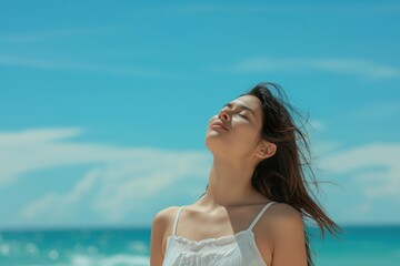 Naklejka premium A young woman breathes the pure sea air on vacation.