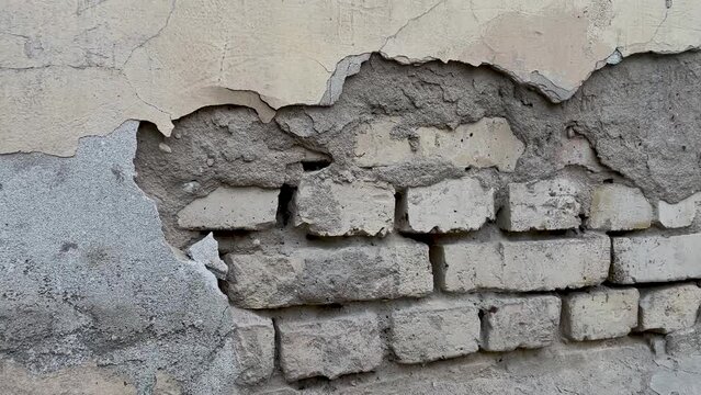 Background of a crumbling brick wall close-up. The texture of a crumbling wall