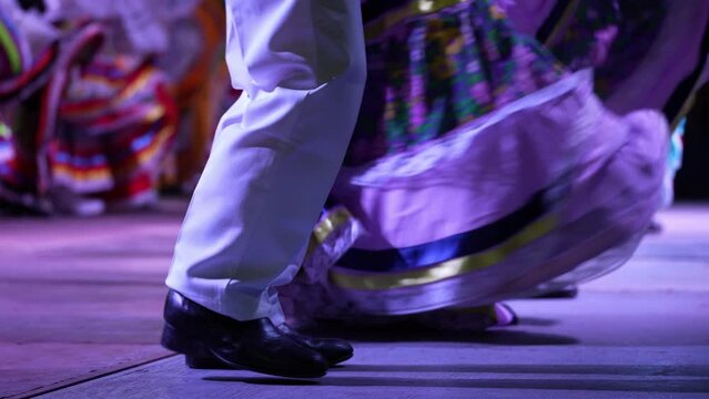 Closeup of men and women dancing a Mexican cultural folk dance sharing the different ethnic dances of La Paz, Baja California Sur, Mexico in slow motion.