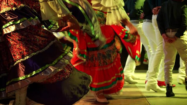 Closeup of men and women dancing a Mexican cultural folk dance sharing the different ethnic dances of La Paz, Baja California Sur, Mexico in slow motion.