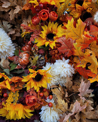 autumn background made of artificial flowers and leaves