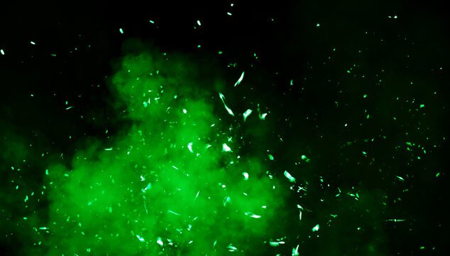 Blurred green fire embers sparks on black background . Texture isolated overlays. Concept of particles, sparkles, flame and light.