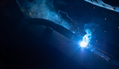 Welding steel structures and bright sparks in steel construction industry. Blue tone