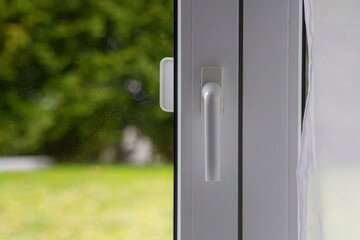 Metal-plastic window with a white handle and curtain. 