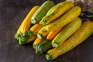 Yellow green leopard spotted zucchini. Vegetables on the table. vegetable marrow harvest. Food background. Fresh courgette, cropped summer squash. Picked courgettes. Still life in kitchen.