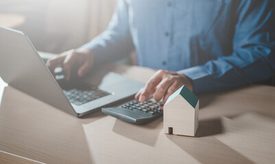 home, loan, money, economy, finance, financial, house, investment, banking, budget. pressing calculators, hand plans home refinance. house model, buy or rent, calculators on desk. saving for property.