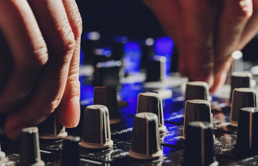 music, technology, people and equipment concept - man using mixing console in sound recording...