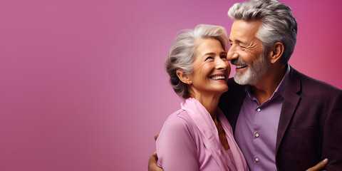 Portrait of happy senior couple looking at camera against purple background with hearts