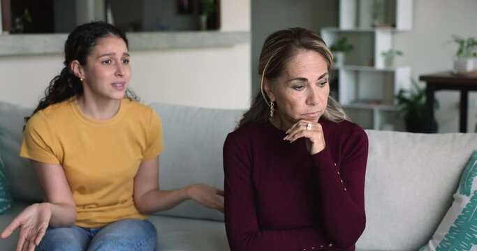 Annoyed teenage daughter express dissatisfaction to frustrated mature mum, about controlling, overprotection and parenting mistakes. Family misunderstanding, relationships problems, generational gap