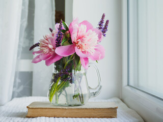 Bouquet of bright flowers standing in a vase on the table. Close-up, no people. Concept of preparation for a holiday. Congratulations for relatives, friends and colleagues