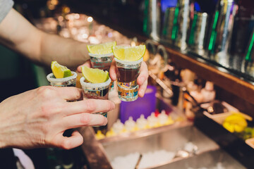 Hand holding a glass with vodka shot.