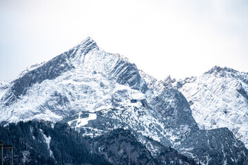 Fototapeta na wymiar Snow-Covered Mountain Peaks Against a Cloudy Sky