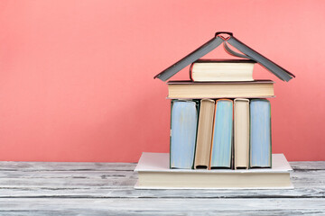 Open book, hardback colorful books on wooden table and red background. Back to school. Copy space...