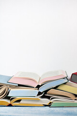 Open book, hardback colorful books on wooden table , white Background. Back to school. Copy space for text. Education business concept.