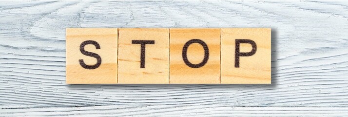 STOP word written on wood block on wooden table. top view. Mockup for design. banner. panorama, banner.