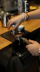 Fototapeta na wymiar professional bartender brewing ground coffee with tamper
