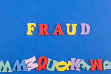 FRAUD word on blue background composed from colorful abc alphabet block wooden letters, copy space for ad text. Learning english concept.