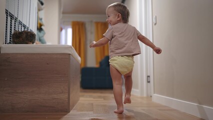 baby run along the corridor indoors. happy family kid dream concept. baby first steps playing run around at home. son, child, active, runs, takes first steps, plays lifestyle indoors - obrazy, fototapety, plakaty