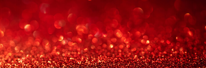 Banner 3:1. Abstract glitter lights on red background. Christmas greating card. Christmas or New Year celebration concept. Copy space. Soft focus.