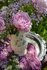 Bouquet of pink peonies in a vase in the garden, background