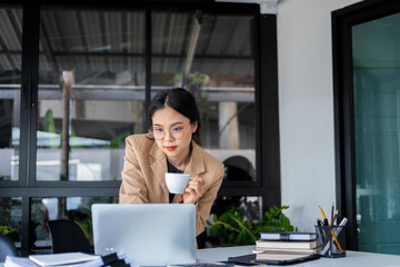 Businesswoman working with laptop and drinking coffee.