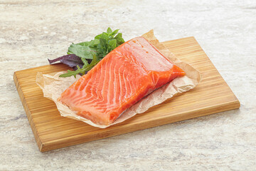 Raw salmon fillet over board