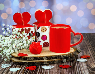 Red cup of coffee with heart, gift boxes, rose candle, gypsophila flowers. Happy Valentine's Day