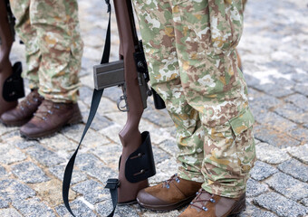 The legs of a Lithuanian camouflage soldier and his rifle