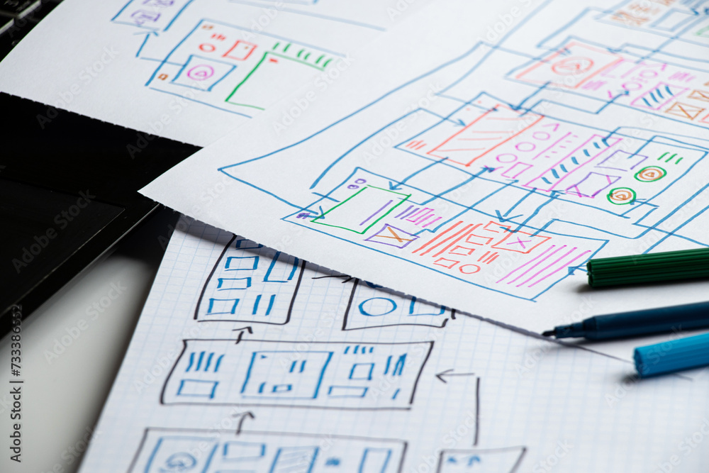 Wall mural development and sketches on paper of a custom mobile application on the desktop, graphic design