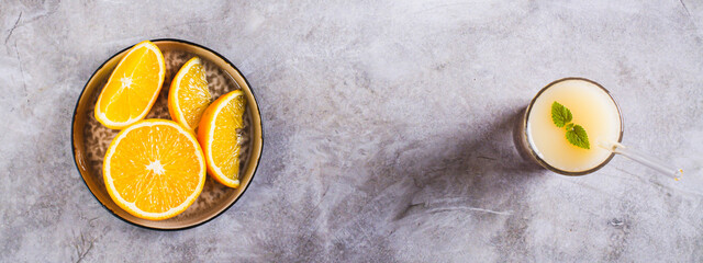 Diet orange smoothie with rice milk in a glass on the table top view web banner