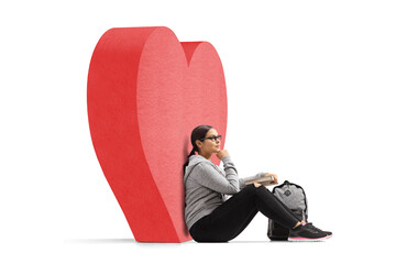 Female student sitting and leaning on a read heart