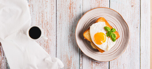 French croque madame hot breakfast sandwich on a plate on the table top view web banner