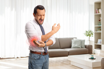 Businessman in pain holding his red inflamed elbow