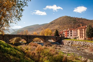 Fototapeta na wymiar bridge and river of ezcaray in northern spain, with clouds and mountains in the background