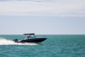 Saltwater fishing boat on a sunny summer day. People on recreational power boat cruising the Gulf of Mexico, Florida.