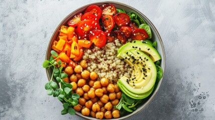  a bowl of chickpeas, tomatoes, avocado, spinach, tomatoes, and chickpeas on a gray surface with a spoon in the middle.
