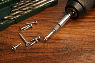 Drill set, screw gun and screws on a dark wooden table. High quality photo