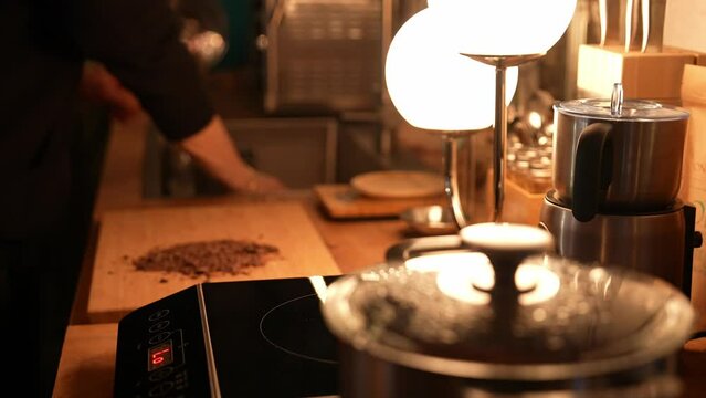 Cocoa making process on the wooden table in a cozy kitchen with a mood lighting. Chef Preparing cocoa drink. High-quality footage closeup cinematic 4k 10 bit. Pouring cocoa into cup.