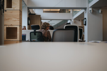 Focused view of professionals in a modern office setting, captured over partition, emphasizing...