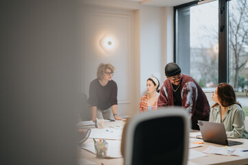 A multi-ethnic group of people collaborates around a laptop in a well-lit contemporary workspace, discussing business strategies.