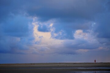 Blue sunrise on Japaratinga beach, Alagoas state, Brazil. First day light on the sea and sky. Clouds and sun light reflections.