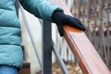 woman holding on to wooden handrail in rainy weather