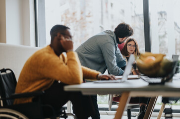 A focused business team collaborates at a bright office space. A moment of teamwork with diverse colleagues in a professional setting.