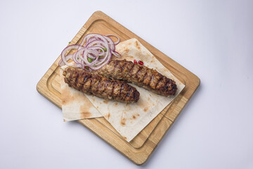 Delicious Lyulya kebab on a wooden board. Close-up 